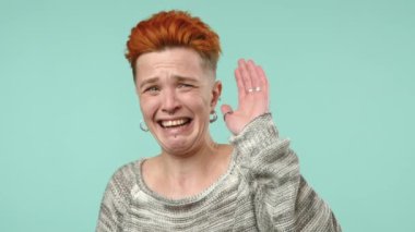 Parlak kızıl saçlı ve şık görünümlü genç bir kadın yüzünü buruşturarak, karşılaştığı tatsız ve tatsız bir şeye tepki olarak eğiliyor.. 