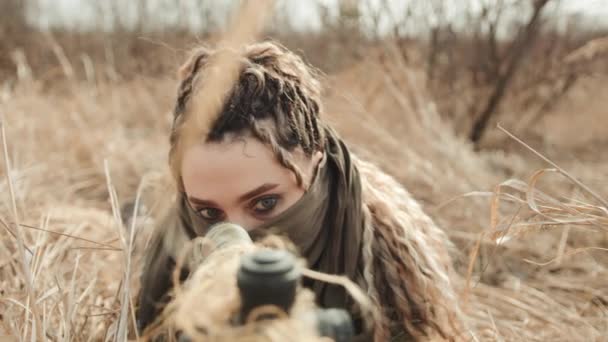 狙撃手の女性がライフル銃の光学的範囲を通って回転するのを見ると カメラは狙撃ライフル銃のマズルに焦点を当てた顔から放出される カメラ Raw — ストック動画