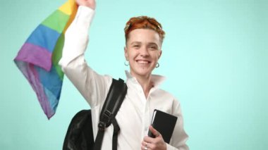LGBT topluluğuna mensup bir öğrenci, elinde bir sırt çantası, notlar ve bir LGBT bayrağı, akademik adanmışlığın güzel bir karışımı ve kimlikleriyle gurur duyuyor. Kamera 8K HAM.