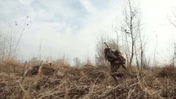 伪装狙击手有目的地穿过未驯服的荒野 搜寻一个有利的位置来等待 8K照相机 — 图库视频影像