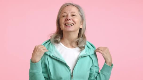 Joyful Senior Woman Removes Her Hoodie Gestures Thanking Audience Charming — Stock Video