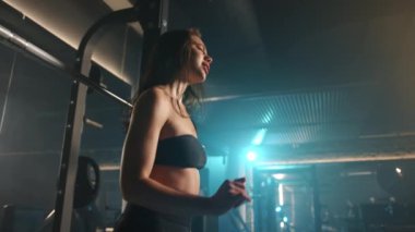 Yoğun halter setleri arasında, hareketli bir kadın dans ederken ve spor salonunda şarkı söylerken neşe saçar, güç egzersizini eğlenceli ve coşkulu bir ritimle yapar. Kamera 8K HAM. 