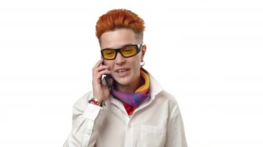 Canlı kızıl saçlı bir kadın cep telefonuyla neşeli bir konuşma yaparken görülüyor, yüzü neşe dolu bir gülümsemeyle aydınlanıyor, pozitiflik saçıyor. Kamera 8K HAM. 