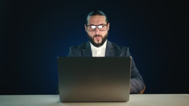 Solemn Businessman Focusing Intently Laptop Screen Dark Blue Background Enhancing — Stock Video