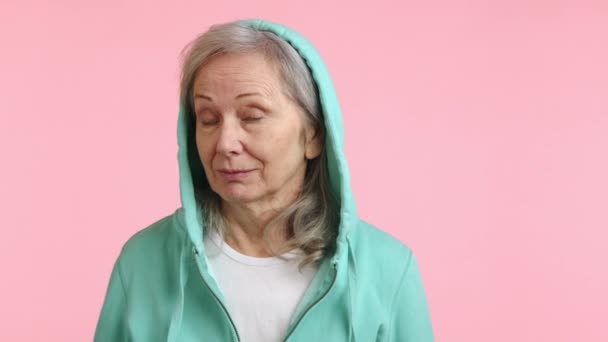 Playful Elderly Woman Mint Hoodie Twirling Her Finger Temple Making — Stock Video