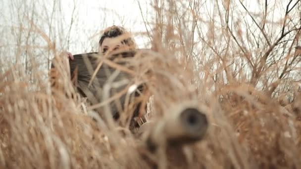 女狙击手穿着带头巾的服装 准备在自然的环境中埋伏 体现了专注和隐秘的技巧 8K照相机 — 图库视频影像