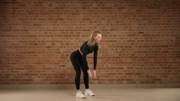 피트니스 트레이너는 건강과 운동에 헌신을 보여주는 소박한 벽이있는 현대적인 체육관 — 비디오