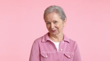 Pembe ceketli mutlu bir son sınıf öğrencisi sıcak bir şekilde gülümsüyor, gözleri sevinçle parıldıyor ve mutlulukla dolu bir kalbi yansıtıyor.. 