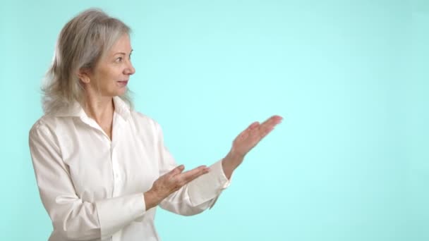 身穿白色展示手势的女商人 指着一个空的空间理想的广告或自定义的文字放置 背景是简约的浅蓝色 8K照相机 — 图库视频影像