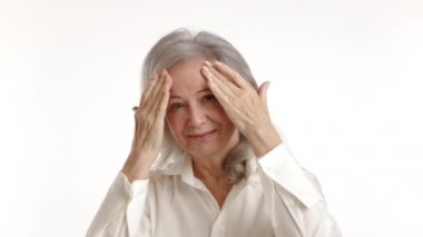 Lütufkar kıdemli bayan, onun yansımasına hayranlık duyuyor, nazikçe yüzüne dokunuyor ve yaşlı teninin kalitesini takdir ediyor, kendini sevme ve özen gösteriyor. Kamera 8K HAM. 