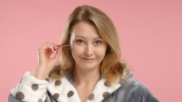 Genç Beyaz Bir Kadın Pamuklu Çubukla Kulaklarını Temizliyor Sade Pembe — Stok video