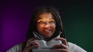 Canlı bir ortamda, rastalı saçlı bir kadın modern bir kulaklık kullanarak sanal gerçekliği keşfediyor. Onun yüz ifadeleri heyecan ve merakı gösteriyor o derin deneyimi derinlemesine incelerken