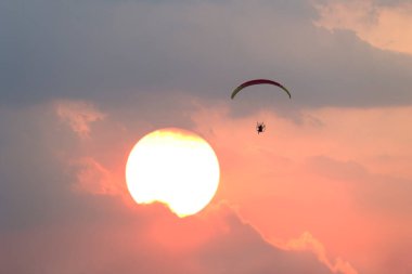 Güneşli arka planlı paramotor sporu
