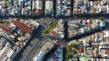 Ho Chi Minh 'in insansız hava aracı, kalabalık bir konağı olan büyük Asya şehri, caddede dolaşan araç kavşağa doğru hareket ediyor, ikamet alanının yakınındaki ev, akşamları gökyüzü manzarası