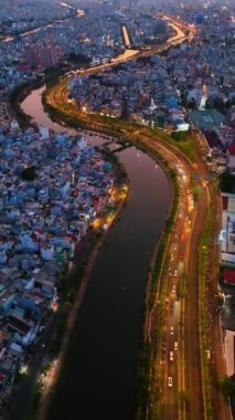 Gece hava manzaralı Asya şehri caddesi, taşıt hareketli koloful yolu, ufuk çizgisi Ho Chi Minh kentsel böylece iş, köprü ile dinamik Sai gon nehri, Vietnam