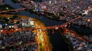 Gece hava manzaralı Asya şehri caddesi, taşıt hareketli koloful yolu, ufuk çizgisi Ho Chi Minh kentsel böylece iş, köprü ile dinamik Sai gon nehri, Vietnam