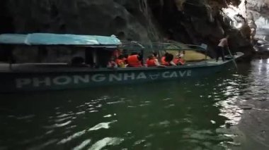 QuANG BINH, VİETİ Adı - 14 Haziran 2024: Kayıkçı kayık Ulusal Park 'taki Phong Nha Ke Bang mağarası, kireçtaşı dağının çekim formasyonu, Vietnam' ın yeraltı varış noktası