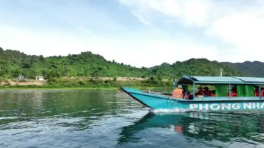 QUANG BINH, VIET NAM - 17 Haziran 2024: Phong Nha Ke Bang Ulusal Parkı 'nı gezmek için tekne nakliyecileri grubu, Vietnam' ın Quang Binh kentindeki Vietnamlıların mirasını görmek için nehre ilerleyin.