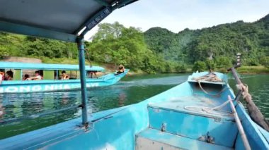 QUANG BINH, VIET NAM - 17 Haziran 2024: Phong Nha Ke Bang Ulusal Parkı 'nı gezmek için tekne nakliyecileri grubu, Vietnam' ın Quang Binh kentindeki Vietnamlıların mirasını görmek için nehre ilerleyin.