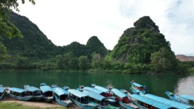 QUANG BINH, VIET NAM - 16 Haziran 2024: Rıhtımda yüzen bir grup tekne, Quang Binh 'deki Phong Nha Ke Bang Ulusal Parkı' nda seyahat eden ulaşım gezgini, dağlık ve nehir kenar mahalleleri