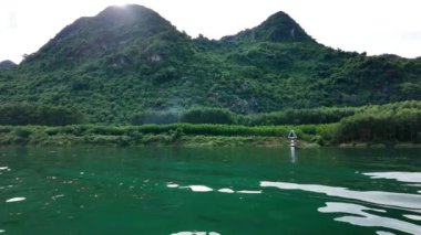Yazın Vietnam 'ı gezmek güzel bir manzara, nehirli kireçtaşı sıradağları, sudaki dalgalar, temiz hava atmosferli yeşil manzaralar sakin bir tatil yapar.