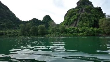 Yazın Vietnam 'ı gezmek güzel bir manzara, nehirli kireçtaşı sıradağları, sudaki dalgalar, temiz hava atmosferli yeşil manzaralar sakin bir tatil yapar.