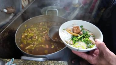 Yavaş çekim aşçısı et suyunu vegan Tayland eriştesine ya da Bun Thai 'ye karıştırıp restoranın mutfağında yemek servis ediyor. Bu ünlü Vietnam sokak yemeği, vejetaryen yemeği sağlığa iyi geliyor.