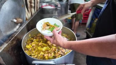 Yavaş çekim aşçısı et suyunu vegan Tayland eriştesine ya da Bun Thai 'ye karıştırıp restoranın mutfağında yemek servis ediyor. Bu ünlü Vietnam sokak yemeği, vejetaryen yemeği sağlığa iyi geliyor.