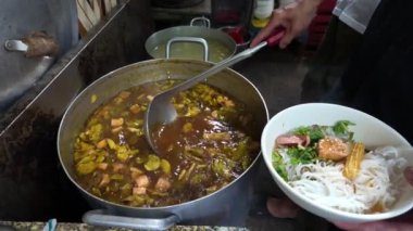 Yavaş çekim aşçısı et suyunu vegan Tayland eriştesine ya da Bun Thai 'ye karıştırıp restoranın mutfağında yemek servis ediyor. Bu ünlü Vietnam sokak yemeği, vejetaryen yemeği sağlığa iyi geliyor.