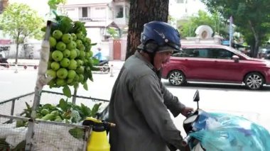 HO CHI MINH CITY, VIETNAM - AUG 20, 2024: Vietnamlı satıcı caddesi; motosiklette göz alıcı bir grup taze guava meyvesi; müşteriler için seyyar satıcı temiz yiyecek; küçük işletme kazancı