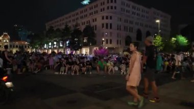HO CHI MINH CITY, VIET NAM - 26 AUG 2024: Nguyen Hue caddesinde gece vakti hareketli atmosfer, kalabalık gençlik ve arkadaşları kamusal alanlarda toplanıyor, hafta sonu gecesi çok eğlenceli