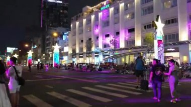 HO CHI MINH CITY, VIET NAM - 26 AUG 2024: Nguyen Hue caddesinde gece vakti hareketli atmosfer, kalabalık gençlik ve arkadaşları kamusal alanlarda toplanıyor, hafta sonu gecesi çok eğlenceli