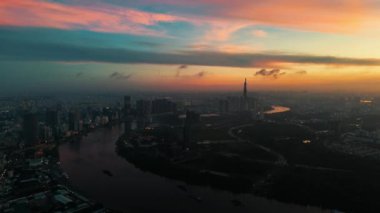 Ho Chi Minh şehrinin sabahın erken saatlerinde inanılmaz bir hava manzarası, Viet Nam, güneşin doğuşuyla etkileyici gökyüzü, canlı kırmızı, renkli doğal ışık ile Saigon kanal sisteminin yüzey suyunu yansıtıyor.