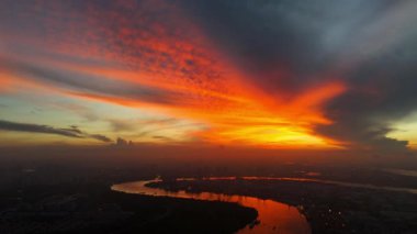 Ho Chi Minh şehrinin sabahın erken saatlerinde inanılmaz bir hava manzarası, Viet Nam, güneşin doğuşuyla etkileyici gökyüzü, canlı kırmızı, renkli doğal ışık ile Saigon kanal sisteminin yüzey suyunu yansıtıyor.