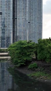 Lüks apartman manzarası nehir yatağını yansıtıyor. Sular çekildiğinde, modern mimarisi olan yüksek binalar, büyük Asya şehrinde.