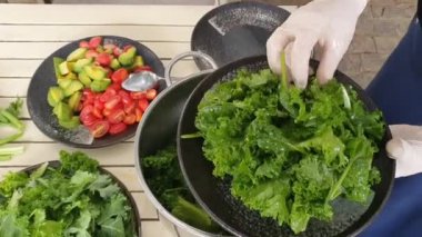 Sağlıklı yemek için taze çiğ besin işleme, sebze sosuyla salatayı karıştırma, avacado, bebek ıspanağı, kristal lettür, kiraz domatesi, vejetaryen canlı yemek.