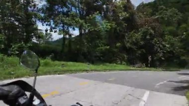 Motosikletle yolculuk, yüksek hızda hareket ettiğinde motorsiklet görüş alanından dönen dağlık arazi düşünce ormanı eğrisinde hareketli bir yolculuk yapar.