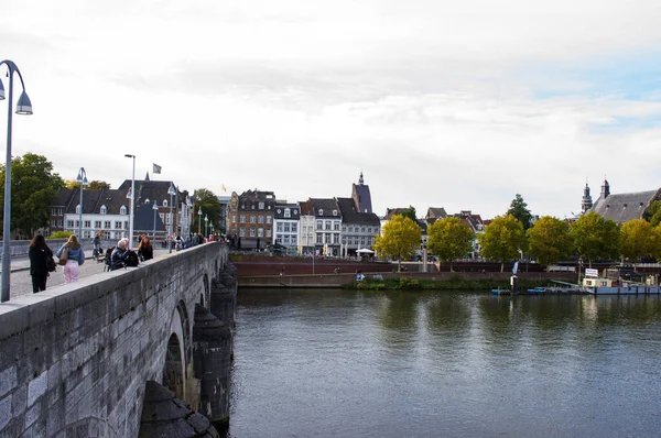 荷兰马斯特里赫特 2022年10月12日 马斯特里赫特市中心的城市景观 前景是人们在默兹河上的一座桥上行走 图库图片