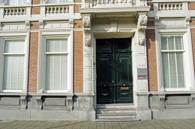 Hollanda, Breda 'da yeşil kapılı ve beyaz pencereli lüks bir malikâneye giriş.