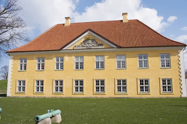 カステルレットの黄色の古い歴史的なカントリーハウス 指揮官は空に雲とコペンハーゲンデンマークの前景に大砲を持つ家 — ストック写真