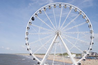 Lahey, Hollanda - 24 Ağustos 2021: Scheveningen 'deki iskelenin dönme dolabı ve arka planda kalabalık bir plaj