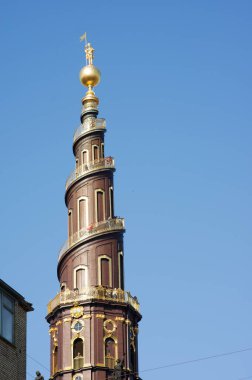 Danimarka 'nın Kopenhag merkezindeki açık mavi gökyüzü ile Kurtarıcımız Kilisesi' nin çarpık kulesi.