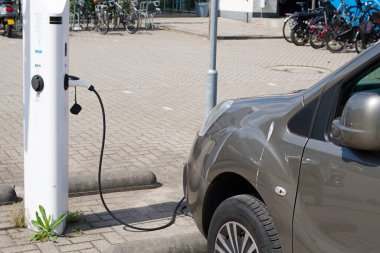 Gri elektrikli araba şarj istasyonuna bağlandı.