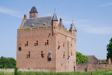 Hollanda 'nın Doornenburg kentindeki ortaçağ şatosu. Gökyüzü masmavi ve bulutlu.