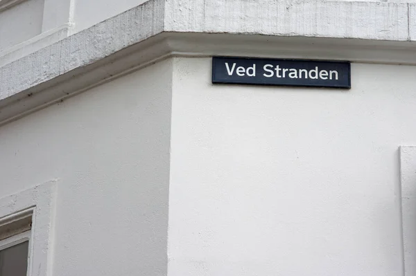 stock image Blue street name sign of Ved Stranden on a white wall in the center of Copenhagen in Denmark