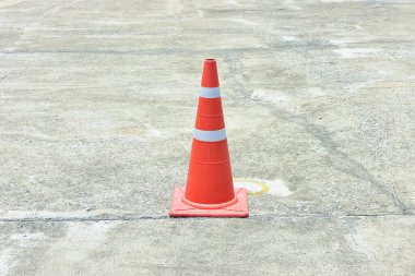 Beton yol yüzeyinde yansıtıcı turuncu trafik konisi .