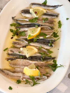 Yüksek açılı taze deniz ürünleri. Bitkilerle süslenmiş ve tabakta servis edilen limon dilimleri.