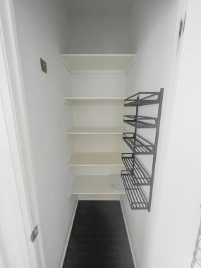 Modern apartmanın duvarına boş ahşap ve metalik raflar monte edilmiş.