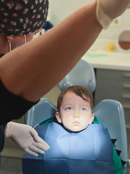Kadın Dişçi Dişçi Kliniğinde Oturan Beyaz Çocuğun Yüzünde Yanan Lambayı — Stok fotoğraf