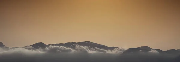 Vista Panorâmica Cênica Nuvens Cobrindo Silhuetas Montanhas Contra Céu Durante — Fotografia de Stock